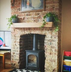 a brick fireplace with potted plants on the mantle