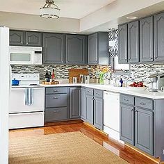 a kitchen with gray cabinets and white appliances