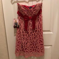 Nwt Pink Lace Dress Strapless But Comes With Straps As An Option Bow In Front Concealed Side Zipper With Eye And Hook Closure Mini Dress Fully Lined With Contrasting Pink Scalloped Bottom Hem Minor Signs Of Age But Not Wear About 31” From Top To Bottom Hem Bust Has Bones Shell: 100% Cotton/100% Silk Lining: 100% Polyester Pink Sleeveless Mini Dress For Holiday, Holiday Strapless Dress For Prom, Holiday Strapless Fitted Dress, Holiday Fitted Strapless Dress, Strapless Fitted Holiday Dress, Lace Strapless Dress, Pink Lace Dress, Strapless Lace Dress, Lace Pink Dress