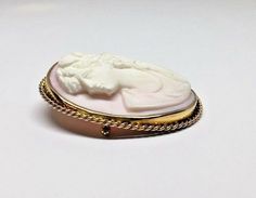 Large 10k Yellow Gold Oval Pink Conch Shell High Relief Cameo Brooch Pin PendantMetal: 10K yellow gold (acid tested)Weight: 33.6 gramsSize: 55mm long x 45mm wide (including frame), Sits 11mm off surface (at highest point)Hallmarked: Symbol of a roseHidden swivel fold down bail enables the brooch to be worn as a pendant or a pin Pin and closure work perfectlyThis is an estate piece in very good condition, it is in it's original worn state and can be re-polished upon request.Please see pictures fo White Oval Cameo Brooches, White Oval Brooch For Formal Occasions, Collectible Oval Cameo Brooch, Oval Cameo Brooches As Gift, Collectible Oval Cameo Brooches, White Oval Brooch For Anniversary, Oval Intaglio Brooches For Anniversary, Yellow Gold Oval Cameo Brooch, Oval Cameo Brooch For Anniversary