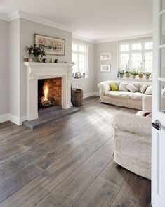 a living room filled with furniture and a fire place in the middle of the room