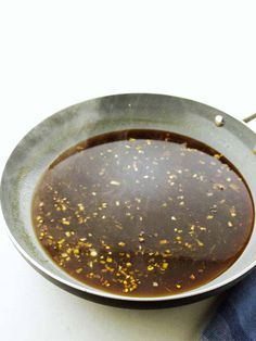 a pan filled with food sitting on top of a white counter next to a blue towel