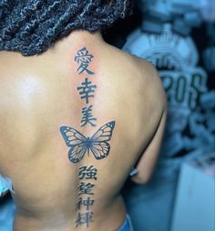 the back of a woman's upper body with chinese writing and butterflies on it