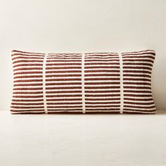 a brown and white striped pillow sitting on top of a table