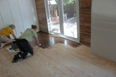 two people laying on the floor in an unfinished room