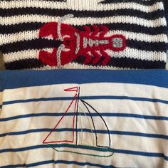 two sweaters with embroidered sailboats on them