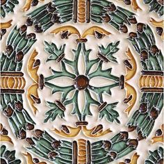 an artistic tile design with green and yellow accents on it's surface, in the shape of a flower