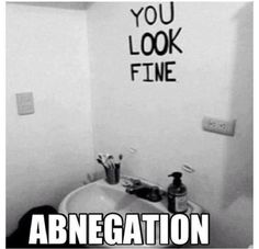 a black and white photo of a bathroom with graffiti written on the wall above it