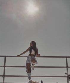 a woman standing on top of a metal rail