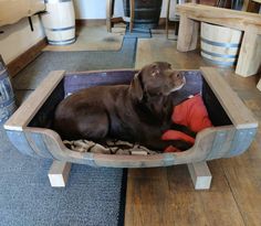 a brown dog laying in a wooden crate