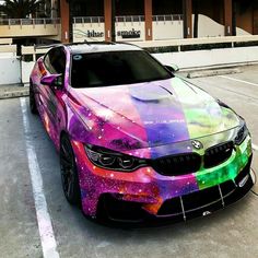 a colorful car parked in front of a building with an artistic paint job on it