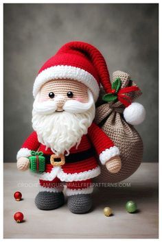 a crocheted santa clause holding a sack of presents and balls in front of him