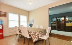 the dining room table is set with white chairs