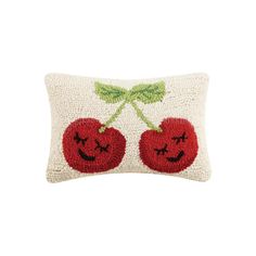 an embroidered pillow with two cherries on it