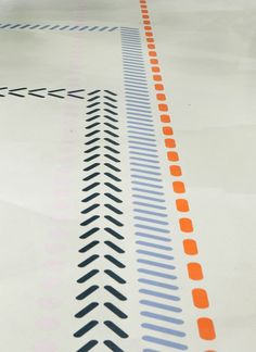 an orange and blue line is on the floor in front of a white background with black dots