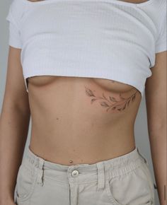 a woman's stomach with a small tattoo on her left side and the bottom part of her body