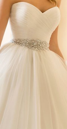 the dress is white and has a crystal belt