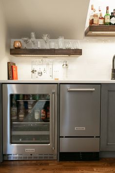 a stainless steel refrigerator with the door open and shelves above it, in a kitchen