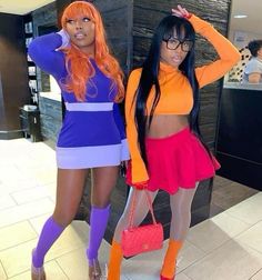 two women dressed in colorful outfits standing next to each other with their hands on their hipss