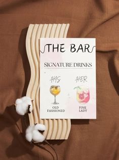 the bar sign is next to cotton floss on a brown sheet with text that reads, the bar signature drinks