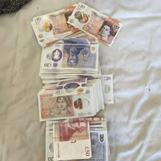 a pile of money sitting on top of a bed