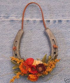 an old pair of scissors is adorned with flowers and leaves on a denim cloth background