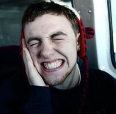 a smiling man wearing a red and white knitted hat on top of his head