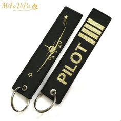 two black and gold key chains with the words pilot on them