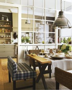 a dining room table and chairs in front of a window with lots of glass panes