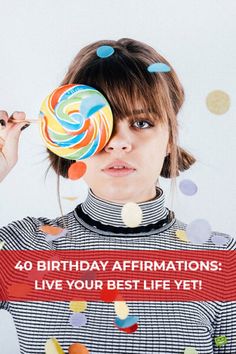 a woman holding a lollipop in front of her face