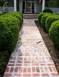 a brick walkway leading to a white house