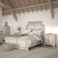 a white bed sitting in a bedroom on top of a wooden floor next to two nightstands