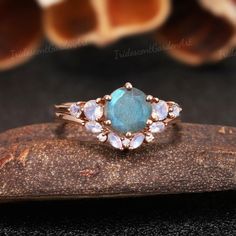 a ring with an oval blue stone surrounded by small white stones