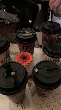 six coffee cups sitting on top of a table covered in music notes and a flower