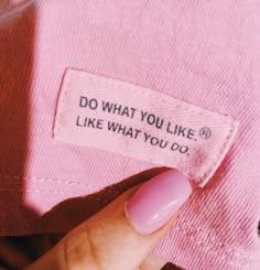 a woman's hand holding onto a pink shirt that says do what you like, like what you do