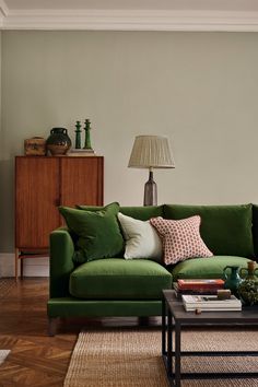 a living room with a green couch and coffee table