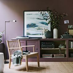 a living room filled with furniture and a painting on the wall above it's bookshelf