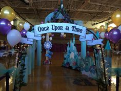 the entrance to once upon a time is decorated with balloons and streamers for an event