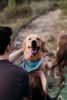 a man and woman holding a dog in their arms