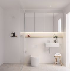 a white bathroom with a toilet, sink and shower stall in the middle of it