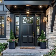 a black front door with two planters on the steps