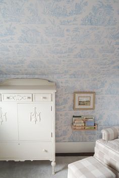 a baby's room with blue and white wallpaper