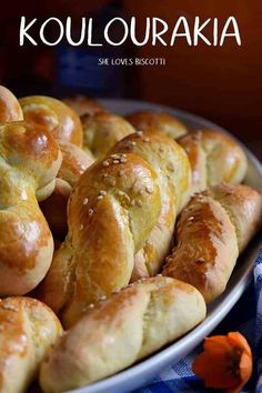 a plate full of bread rolls with sesame seeds on top and the words koulouraka above it