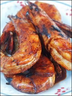 grilled shrimp on a white and red plate