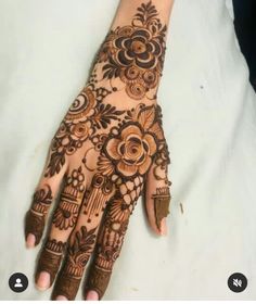 a henna on someone's hand that is showing the intricate designs and colors