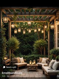 an outdoor seating area with lights strung from the ceiling and potted trees in the background