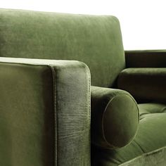 a green couch sitting on top of a wooden floor