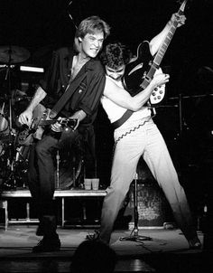 two men are playing guitars on stage