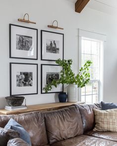 a living room with couches and pictures on the wall above them in black and white