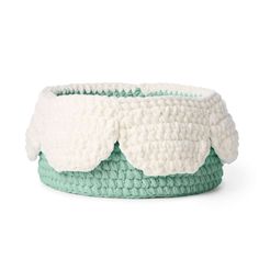 a green and white crocheted basket on a white background